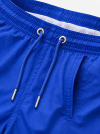 Close-up of a pair of bright blue athletic shorts showing the elastic waistband, blue drawstrings with silver metal tips, and a white mesh lining.