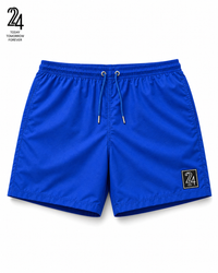 Bright blue athletic shorts with a drawstring waist and a small black square logo patch on the lower left leg, shown on a white background with a small '24' brand graphic in the top-left corner.